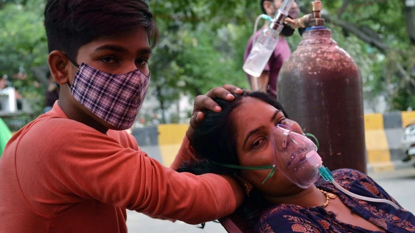 coronavirus A son takes care of his COVID-19 mother who takes breathe with the support of an oxygen cylinder provided for free by Indirapuram Gurudwara amid a shortage of Oxygen gases, in Ghaziabad on Sunday.