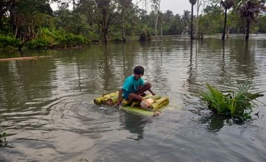 Cyclone-induced rain submerges many villages in three Odisha districts A boy rides on a makeshift boat on waterlogged street aftermath of cyclone Yaas, at Kultali in South 24 Parganas on Thursday.