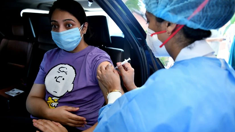 coronavirus, vaccination A healthcare worker injects a woman with a dose of covaxin against the coronavirus during the drive-in vaccination center at Moolchand Hospital, in New Delhi.