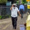 People seen walking amid rain showers, at Connaught place, in New Delhi